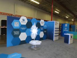 Reconfigurable Gravitee Custom Inline with SEG Fabric Graphic and Printed Hexagon Felt Graphics, LED Accent Lights, Magnetic Attachments, Shelves, Locking Closet, Reception Counter w/ Locking Storage, and Modified MOD-1464 Wireless Charging Table